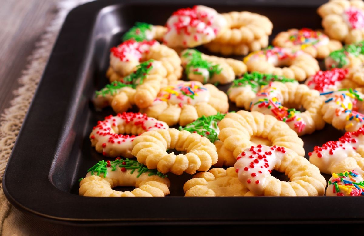 Holiday spritz cookies with icing on tray